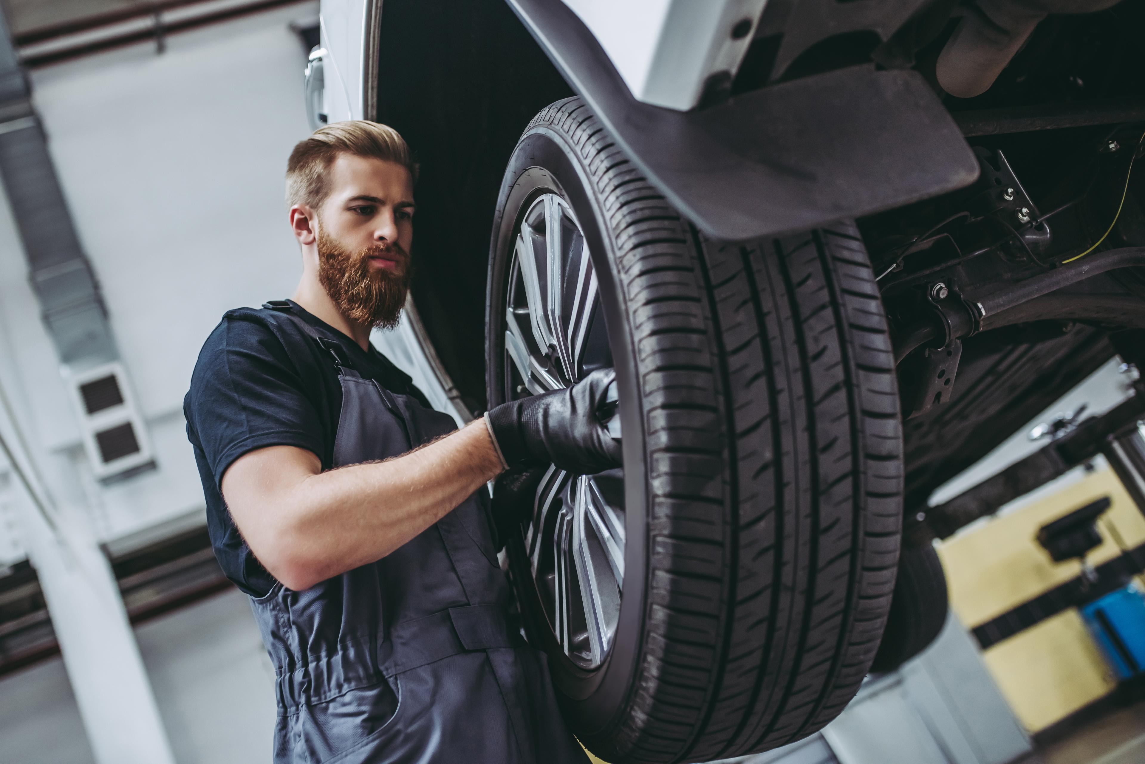 Mechanic readies cars for spring excursions with tire changes.